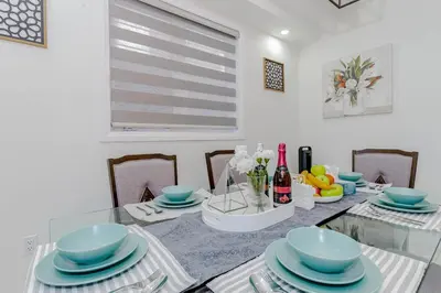 a dining room with a glass table with blue dishes at Amazing Home in Niagra Region in Thorold