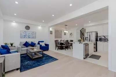 a living room and kitchen with a couch and a table at Amazing Home in Niagra Region in Thorold