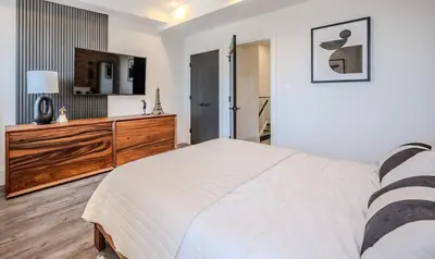 a bedroom with a bed and a dresser and a television at Charming 2 Bed Apartment in Cambridge