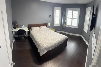 a bedroom with a bed and a table with a desk at Q88 luxury Sunny room in Mississauga
