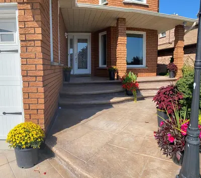 a brick house with a front porch with flowers at Q88 luxury Sunny room in Mississauga