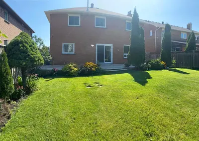 a house with a yard with a grass yard at F3 Spacious room with 2 queen beds and TV in Mississauga