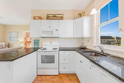 a kitchen with white cabinets and a sink at The Lynx - 35 Butternut in Cherry Valley