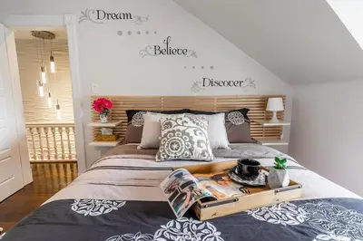 a bedroom with a large bed with a wooden headboard at Modern City Suite with Rooftop Patios in Toronto