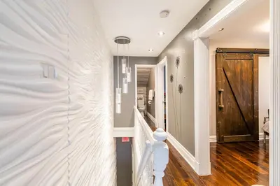 a staircase in a home with a white wall at Modern City Suite with Rooftop Patios in Toronto