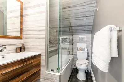 a bathroom with a toilet and a glass shower at Modern City Suite with Rooftop Patios in Toronto