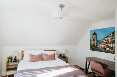 a bedroom with a bed and a painting on the wall at Park and Mill - Hot Tub and Bocce Court in Bloomfield