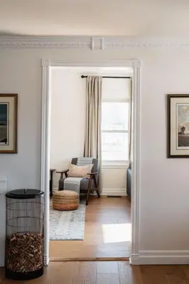a living room with a door open to a room with a chair at Park and Mill - Hot Tub and Bocce Court in Bloomfield