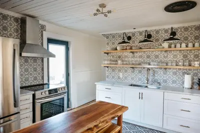 a kitchen with white cabinets and a stove top oven at Park and Mill - Hot Tub and Bocce Court in Bloomfield