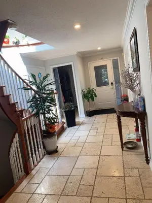 a hallway with a staircase with potted plants and a table at 201 Large Private Bedroom on second floor in Mississauga