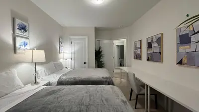 a bedroom with two beds and a desk in it at Exquisite Luxury Townhomes in Elite Angus Glen Estate in Markham