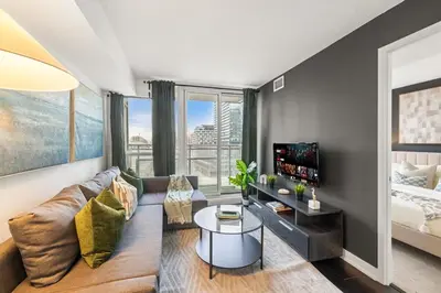 a living room with a couch and a tv at Modern 1BR King Suite, Central Downtown Toronto in Toronto