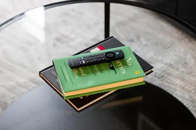 a remote control sitting on top of books on a table at Modern 1BR King Suite, Central Downtown Toronto in Toronto
