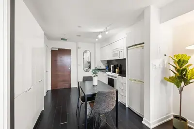 a kitchen with a table and chairs and a refrigerator at Modern 1BR King Suite, Central Downtown Toronto in Toronto