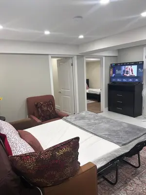 a bedroom with a large bed and a flat screen tv at Private 2bedroom Unit, Free Parking, Free from Smoke & Pet, Self-Check IN in Pickering