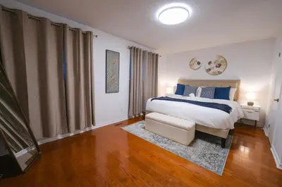 a bedroom with a king sized bed and a television at Spacious 4 bedroom Home - 15 mins from YYZ airport in Mississauga