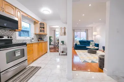 a kitchen with a stove and a living room at Spacious 4 bedroom Home - 15 mins from YYZ airport in Mississauga