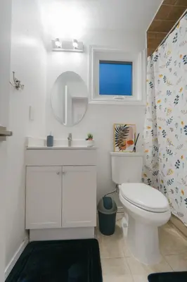 a bathroom with a toilet and a sink and a mirror at Spacious 4 bedroom Home - 15 mins from YYZ airport in Mississauga
