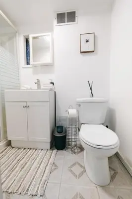 a white bathroom with a toilet and a sink at Spacious 4 bedroom Home - 15 mins from YYZ airport in Mississauga