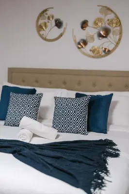 a bed with blue and white pillows on it at Spacious 4 bedroom Home - 15 mins from YYZ airport in Mississauga