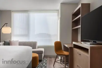 a living room with a large window and a television at Hyatt House Mississauga / Airport Corp Center in Mississauga
