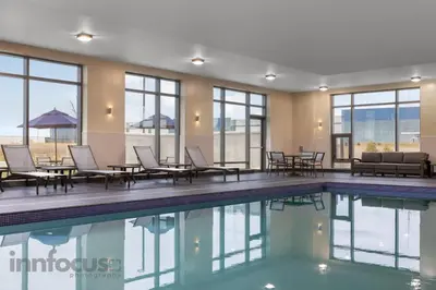 a pool with chairs and tables in a building at Hyatt House Mississauga / Airport Corp Center in Mississauga
