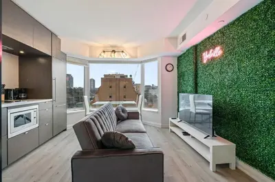 a living room with a couch and a green wall at Luxurious Suite in Yorkville in Toronto