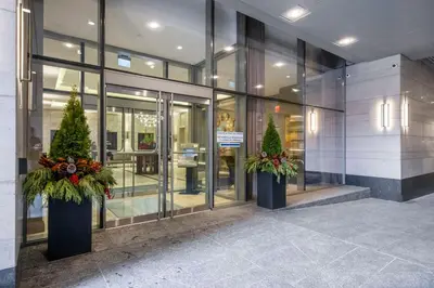 a building with two potted trees in front of it at Luxurious Suite in Yorkville in Toronto