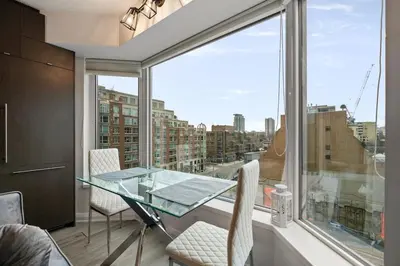 a dining room with a glass table and a large window at Luxurious Suite in Yorkville in Toronto