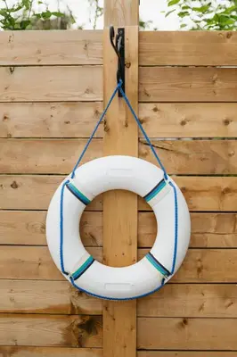 a white and blue life raft hanging on a wooden wall at Marina and Main - In Ground Pool and Games Room in Wellington