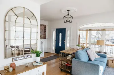 a living room with a blue couch and a table at Marina and Main - In Ground Pool and Games Room in Wellington