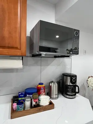 a kitchen counter with a microwave above a coffee maker at St Catharines Niagara Escape in St. Catharines