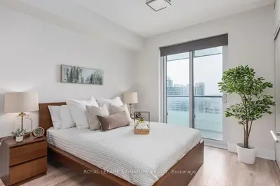 a bedroom with a bed and a large window at Belarte Suites - Downtown Toronto - CN Tower & Rogers Centre in Toronto