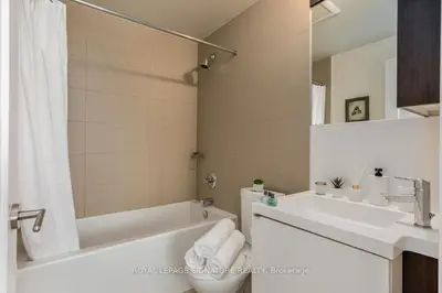 a white bathroom with a tub and a sink at Belarte Suites - Downtown Toronto - CN Tower & Rogers Centre in Toronto