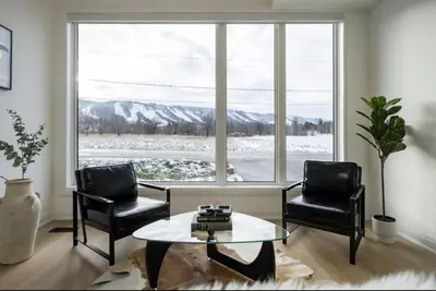 a living room with two chairs and a table and a window at The Luxury Black Rose Chalet at The Blue Mountains for 20 in Blue Mountains