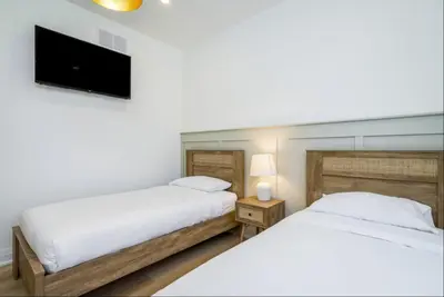 a bedroom with two beds and a flat screen tv at The Luxury Black Rose Chalet at The Blue Mountains for 20 in Blue Mountains