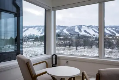 a room with a table and two chairs and two windows at The Luxury Black Rose Chalet at The Blue Mountains for 20 in Blue Mountains
