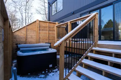 a wooden staircase leading up to a house with snow at White Rose Chalet at Blue Mountains for 20 w Hot Tub in Blue Mountains
