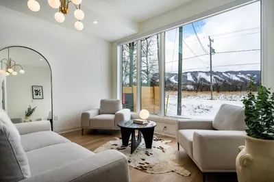 a living room with couches and a large window at White Rose Chalet at Blue Mountains for 20 w Hot Tub in Blue Mountains