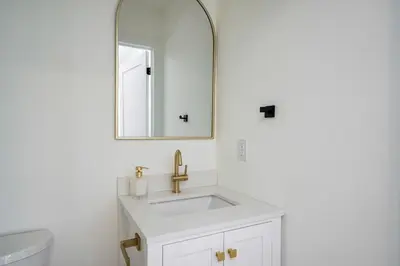 a white bathroom with a sink and a mirror at White Rose Chalet at Blue Mountains for 20 w Hot Tub in Blue Mountains