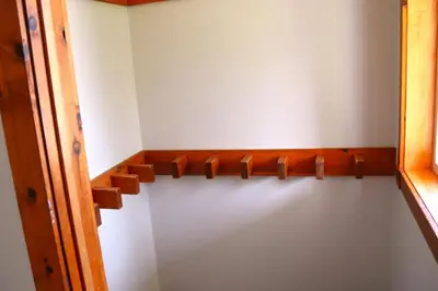 a closet with a wooden shelf on the wall at The Blue Mountains Chalet for 20- 8BR Bliss w Hot Tub in Blue Mountains