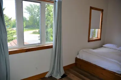 a bedroom with a bed and a window at The Blue Mountains Chalet for 20- 8BR Bliss w Hot Tub in Blue Mountains