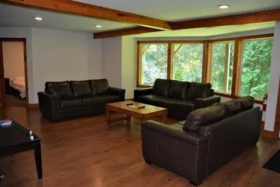 a living room with two leather couches and a coffee table at The Blue Mountains Chalet for 20- 8BR Bliss w Hot Tub in Blue Mountains