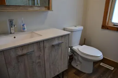 a bathroom with a white toilet and a sink at The Blue Mountains Chalet for 20- 8BR Bliss w Hot Tub in Blue Mountains