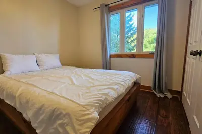 a bedroom with a large bed with a window at All-Season 8BR Vacation Chalet in Blue Mountains