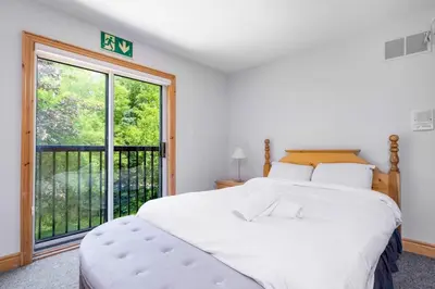 a bedroom with a large white bed and a large window at The Four Leaf Clover at The Blue Mountains for 12 in Blue Mountains