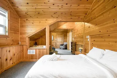 a bedroom with a large bed in a wooden room at The Four Leaf Clover at The Blue Mountains for 12 in Blue Mountains