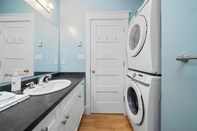 a bathroom with a sink and a washer and dryer at The Cattail - 26 Meadowview in Cherry Valley
