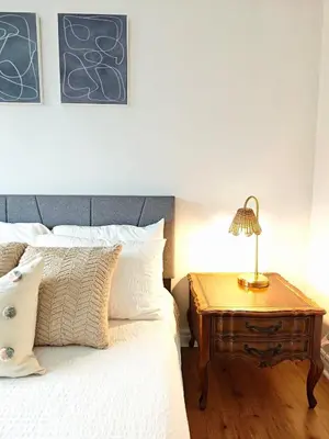 a bedroom with a bed and a nightstand with a lamp at Luxury Old Town Winter Retreat- Hot Tub and Games in Niagara on the Lake