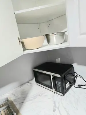a microwave sitting on a counter in a kitchen at Welcome to your Serene Gateway in London